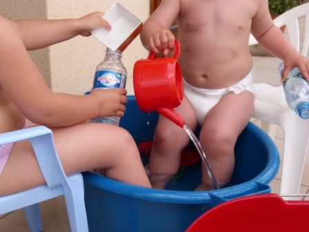 Jouer dans l`eau dans une bassine